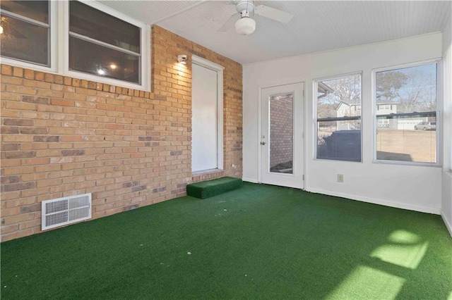 unfurnished sunroom with ceiling fan