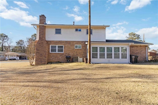 back of property featuring central AC unit and a lawn