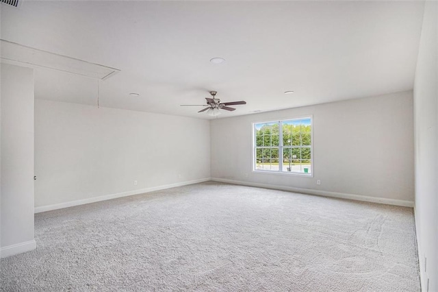carpeted spare room with baseboards and attic access