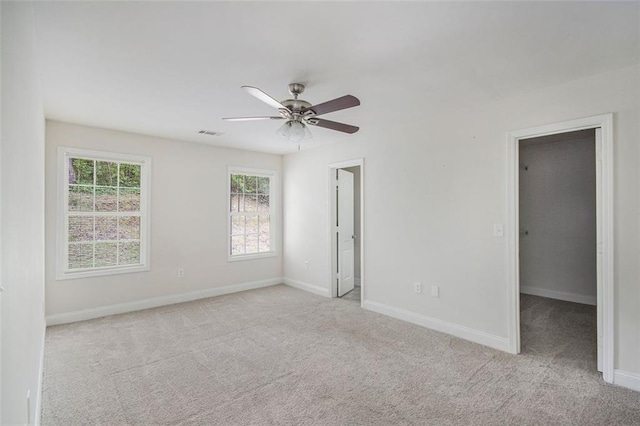 unfurnished bedroom featuring visible vents, baseboards, a walk in closet, and carpet floors