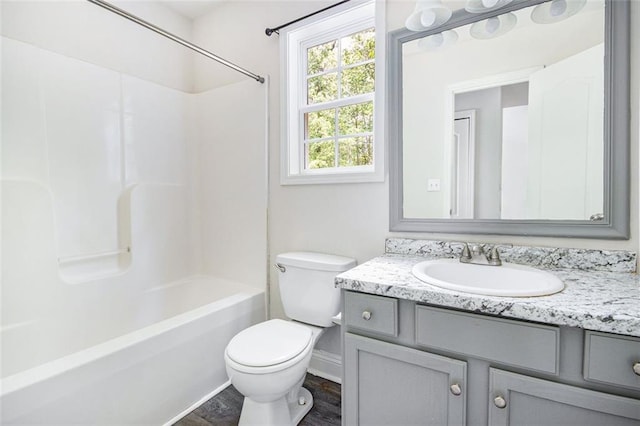 full bath with vanity, wood finished floors, toilet, baseboards, and  shower combination