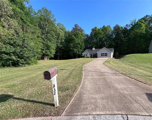 view of front of property featuring driveway and a front yard