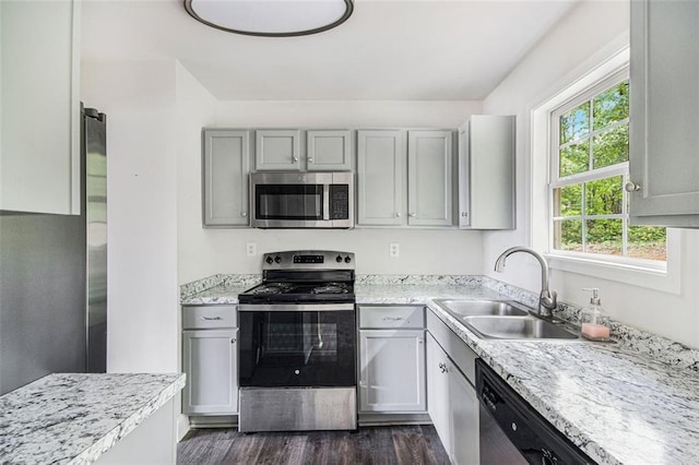kitchen featuring light countertops, stainless steel appliances, a sink, and dark wood-style flooring