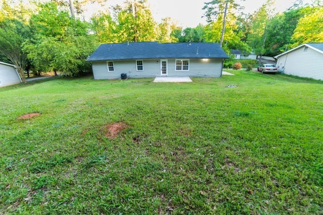 back of house with a yard and a patio