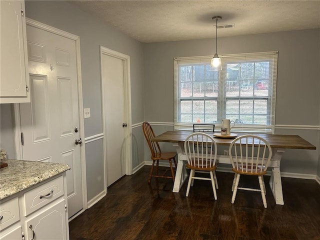 dining space featuring a wealth of natural light, dark hardwood / wood-style floors, and a textured ceiling