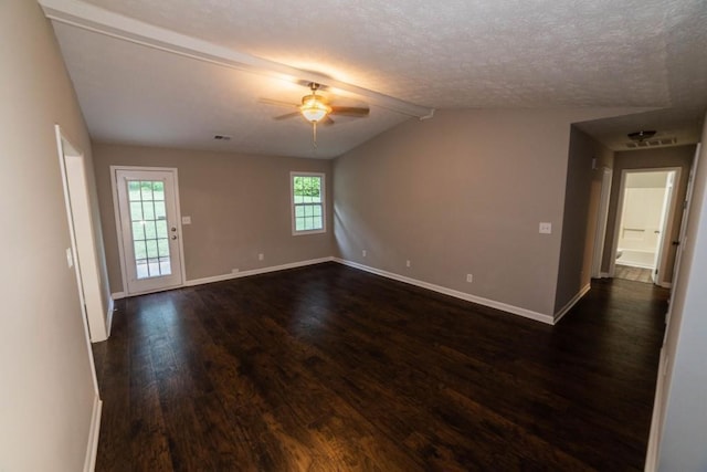 empty room with ceiling fan, dark hardwood / wood-style flooring, lofted ceiling with beams, and a textured ceiling