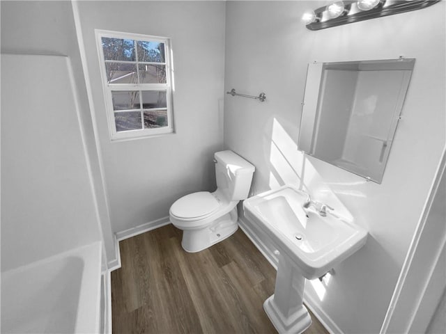 bathroom featuring wood finished floors, toilet, and baseboards