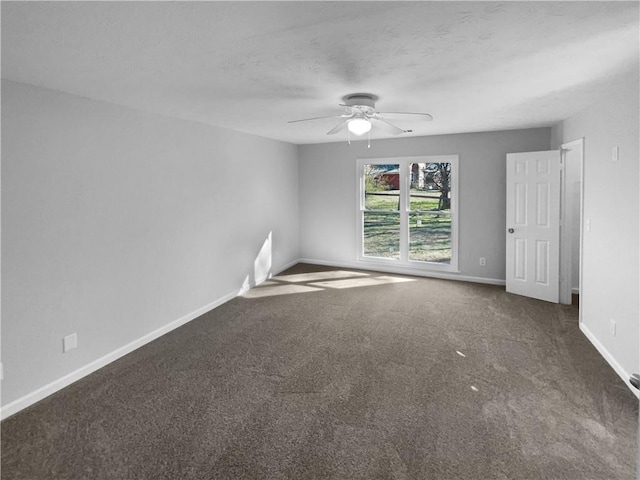 unfurnished room with dark colored carpet, ceiling fan, a textured ceiling, and baseboards