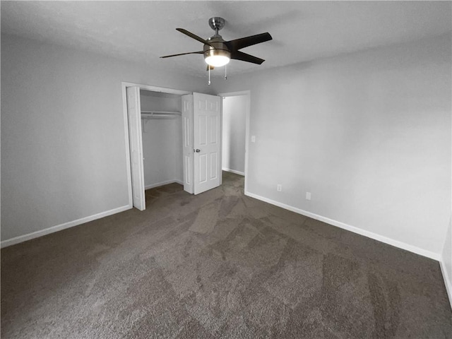 unfurnished bedroom with ceiling fan, dark colored carpet, a closet, and baseboards