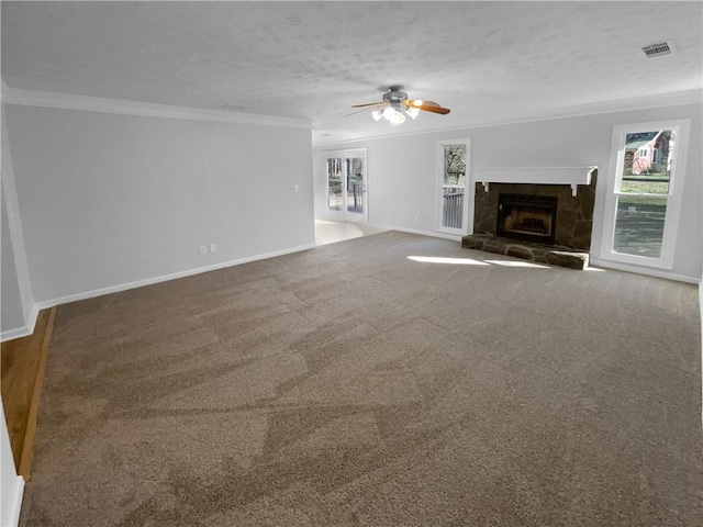 unfurnished living room featuring visible vents, dark carpet, a textured ceiling, and ornamental molding