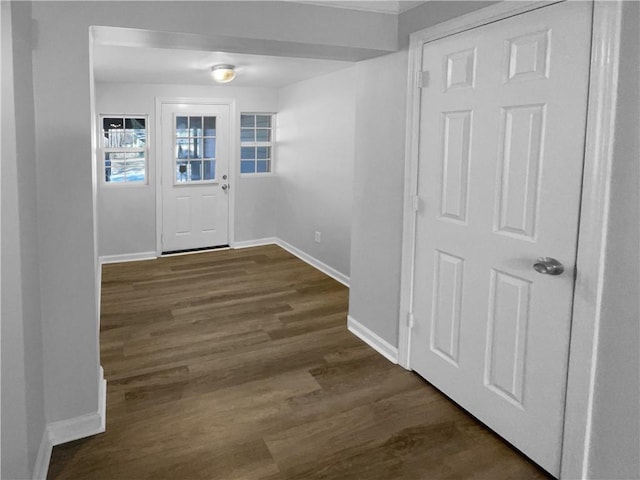 doorway to outside with dark wood-type flooring and baseboards