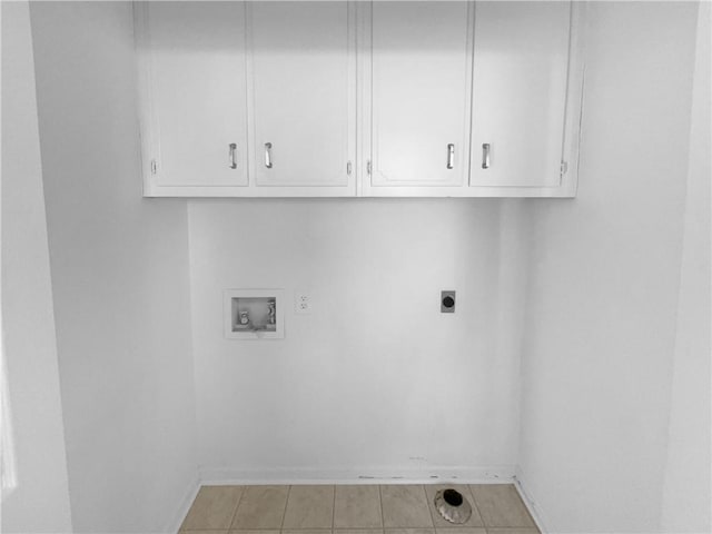 clothes washing area featuring baseboards, washer hookup, cabinet space, and electric dryer hookup