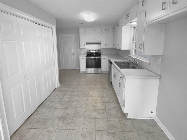 kitchen featuring baseboards, stainless steel appliances, light countertops, white cabinetry, and a sink