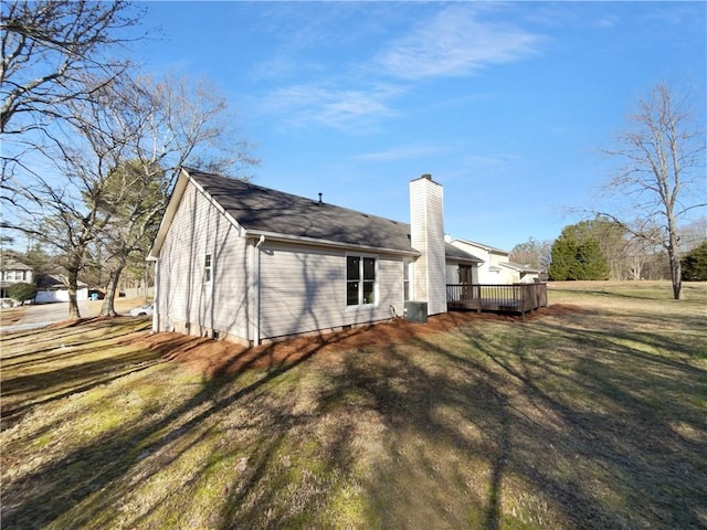 back of property featuring a chimney, a yard, a deck, and central air condition unit