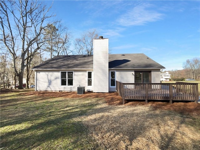 rear view of house with a chimney, central AC, a lawn, and a deck