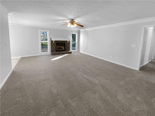 unfurnished living room with ornamental molding, a ceiling fan, a stone fireplace, a textured ceiling, and baseboards