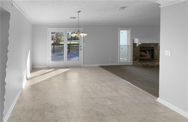 unfurnished dining area with crown molding, visible vents, a stone fireplace, a chandelier, and baseboards