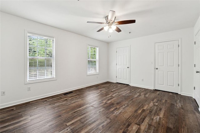 215 Morris Ln, Woodstock, GA 30188 - unfurnished bedroom featuring dark wood-style flooring, baseboards, and a ceiling fan