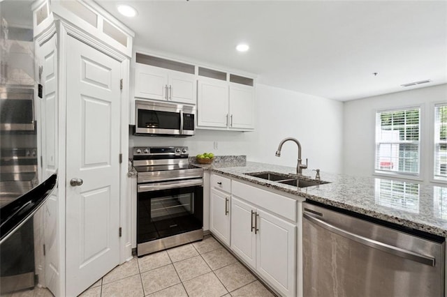 215 Morris Ln, Woodstock, GA 30188 - kitchen featuring appliances with stainless steel finishes, a sink, white cabinets, light tile patterned floors, and recessed lighting