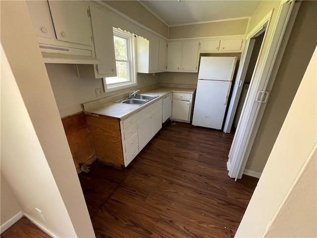 kitchen featuring sink, dark hardwood / wood-style flooring, crown molding, white fridge, and white cabinets