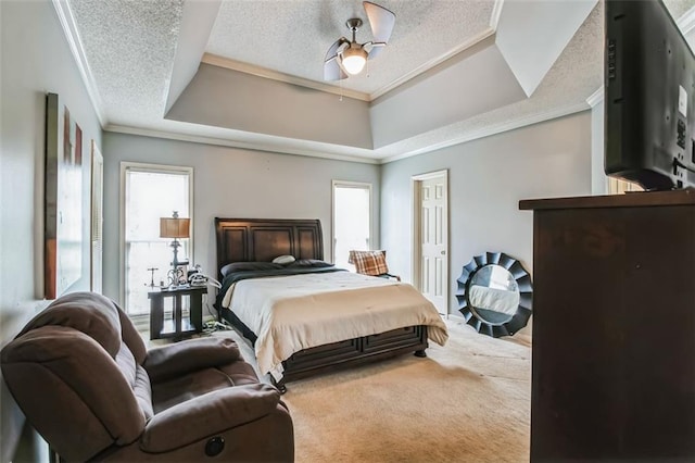 bedroom with multiple windows, a textured ceiling, crown molding, and a raised ceiling