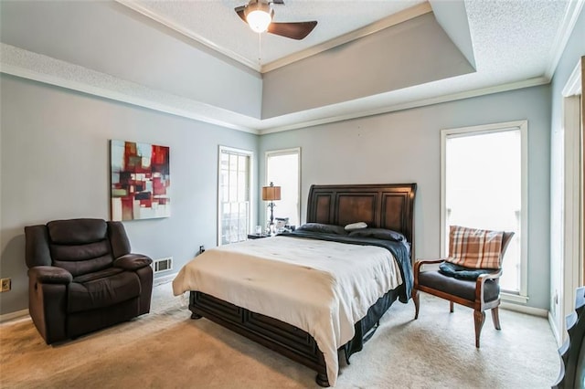 bedroom with crown molding, carpet, ceiling fan, and a raised ceiling