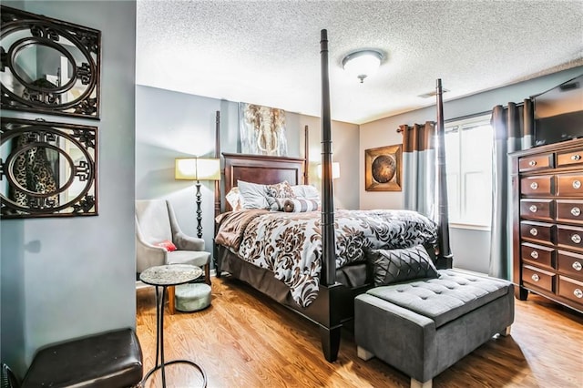 bedroom featuring wood-type flooring and a textured ceiling