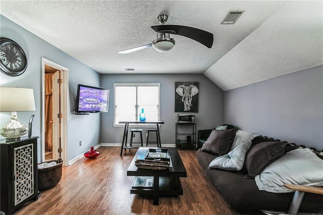 living room with ceiling fan, dark hardwood / wood-style floors, a textured ceiling, and lofted ceiling