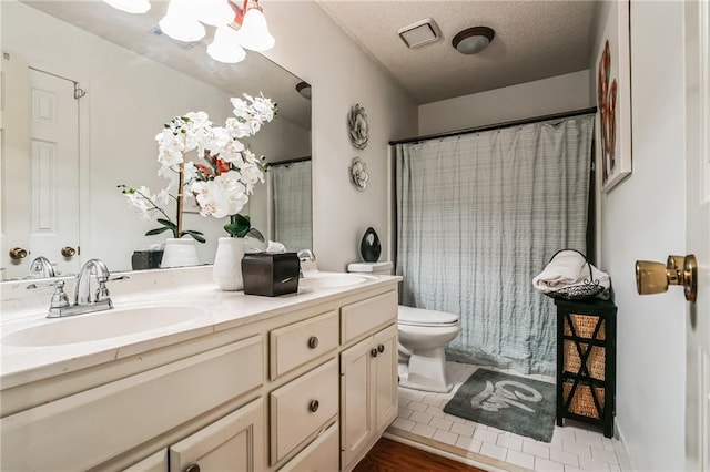 bathroom with a textured ceiling, wood-type flooring, vanity, toilet, and a chandelier