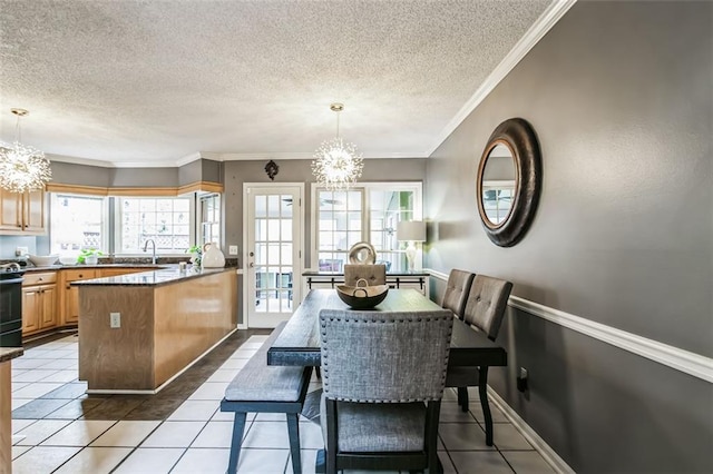 tiled dining area featuring a textured ceiling, ornamental molding, and a notable chandelier