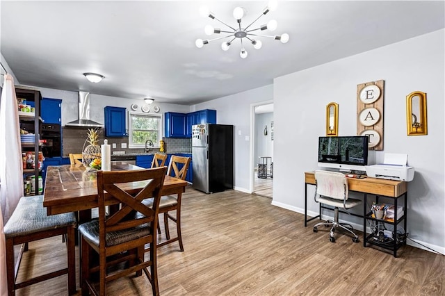 dining room featuring baseboards, a notable chandelier, and light wood finished floors
