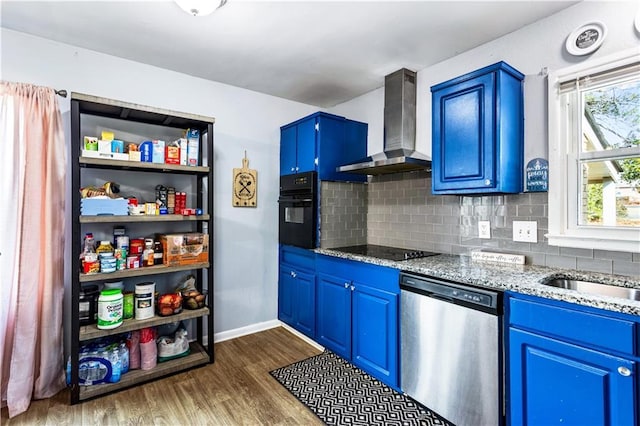 kitchen featuring dark wood-style flooring, wall chimney exhaust hood, light stone countertops, blue cabinets, and black appliances