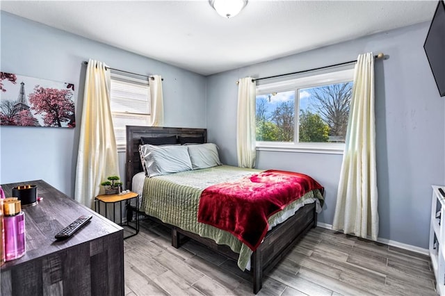 bedroom with light wood-type flooring and baseboards