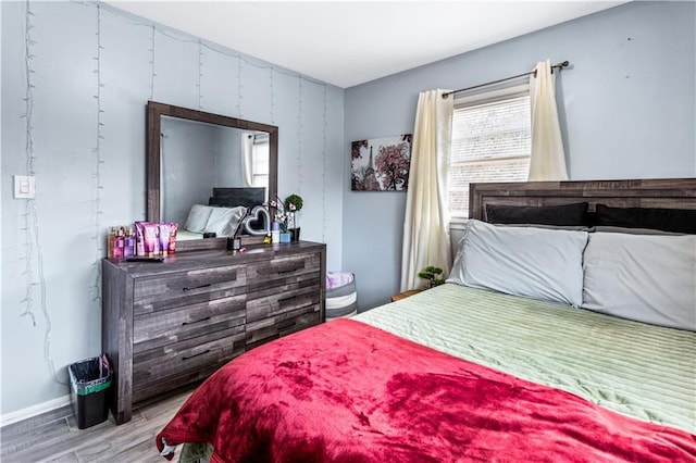 bedroom with light wood-type flooring and multiple windows