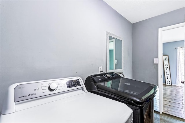 laundry room with laundry area, dark wood finished floors, and washer and dryer