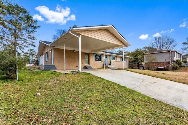 view of front facade featuring driveway, entry steps, a front yard, a carport, and brick siding