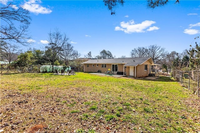 rear view of house featuring a patio area, a fenced backyard, and a lawn
