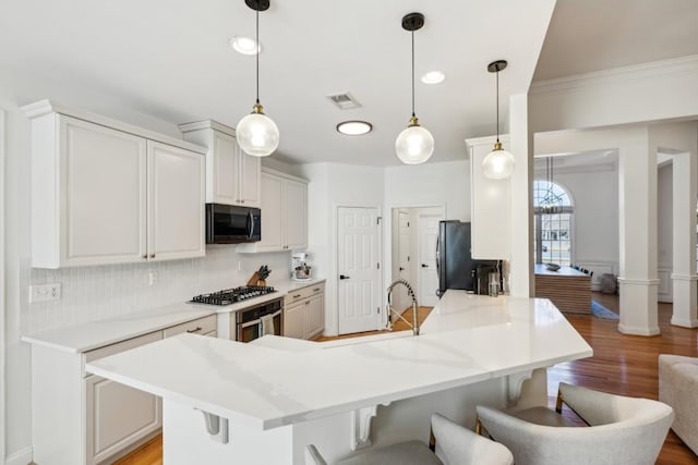 kitchen featuring white cabinets, hanging light fixtures, and a breakfast bar