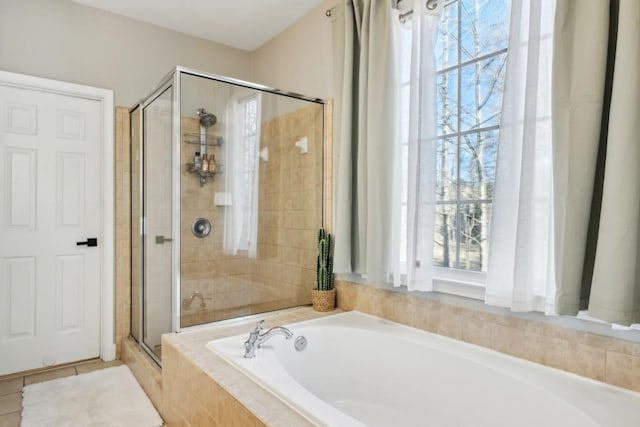 bathroom with plus walk in shower, tile patterned flooring, and a wealth of natural light