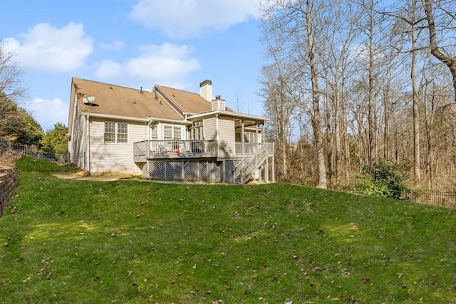 back of property with a deck and a lawn