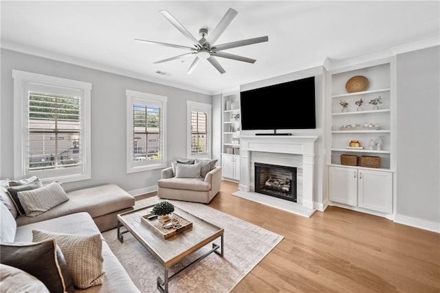 1104 Thomas St, Woodstock, GA 30188 - living area featuring a fireplace with raised hearth, light wood-type flooring, a ceiling fan, and built in features