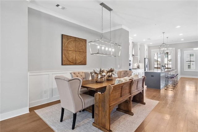 1104 Thomas St, Woodstock, GA 30188 - dining space with light wood-type flooring, a chandelier, ornamental molding, and recessed lighting