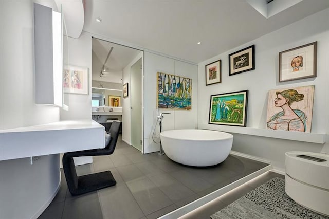 full bathroom with a freestanding tub and baseboards