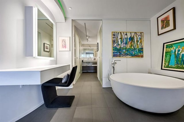 bathroom featuring a soaking tub, tile patterned flooring, and vanity