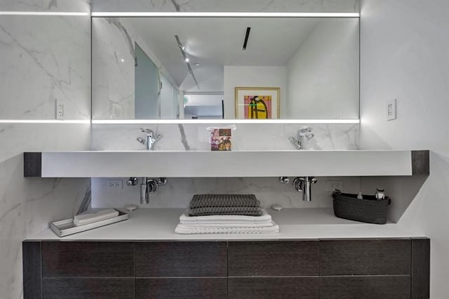 bathroom featuring decorative backsplash and dual sinks