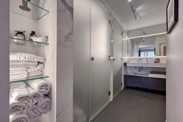 bathroom featuring a shower, tile patterned flooring, vanity, and track lighting