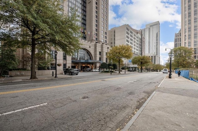 view of road with street lighting, a view of city, curbs, and sidewalks