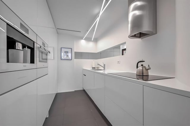 kitchen featuring white cabinetry, modern cabinets, black electric stovetop, and light countertops