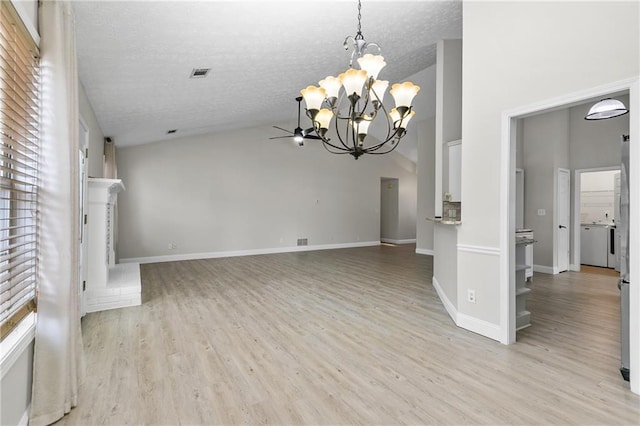 unfurnished living room with a textured ceiling, high vaulted ceiling, light hardwood / wood-style floors, and ceiling fan with notable chandelier