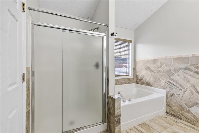 bathroom with a textured ceiling, tile walls, and independent shower and bath